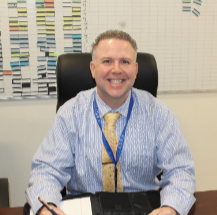 Principal Edward Smith sits at his desk