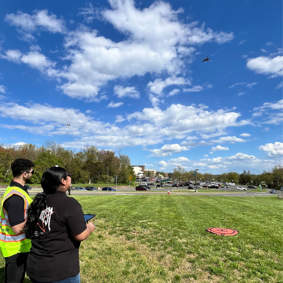 A student works with instructor to fly a drone.